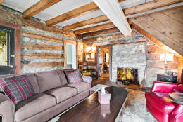 The original structure includes wide plank floors and a stone fireplace and chimney. (Courtesy Long & Foster Real Estate)