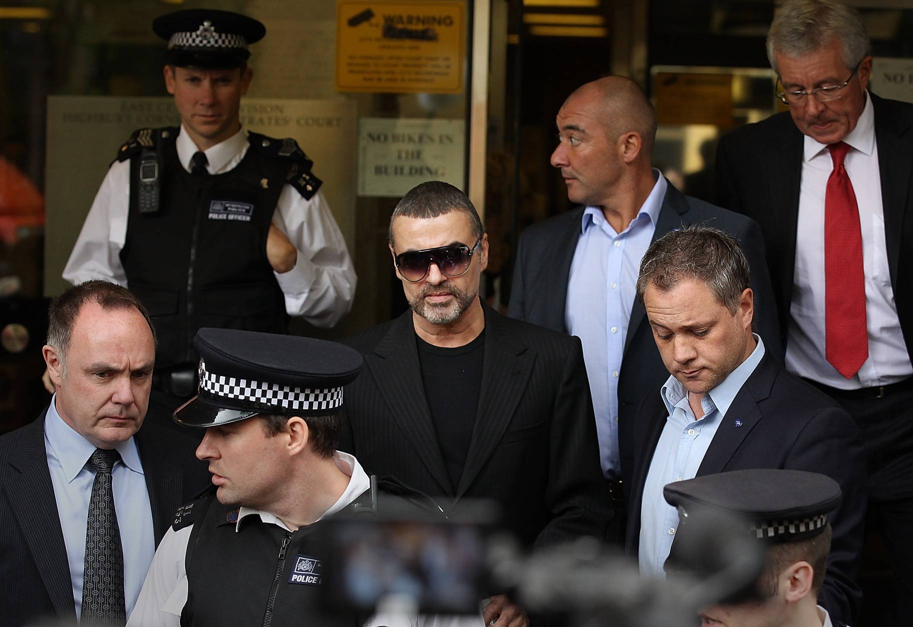LONDON, ENGLAND - AUGUST 24:  Singer George Michael (C) leaves  Highbury Corner Magistrates Court surrounded by press and police on August 24, 2010 in London, England. Mr Michael pleaded guilty to driving under the influence of drugs and possessing cannabis after he crashed his car into a photo processing shop in London on July 4, 2010.  (Photo by Peter Macdiarmid/Getty Images)