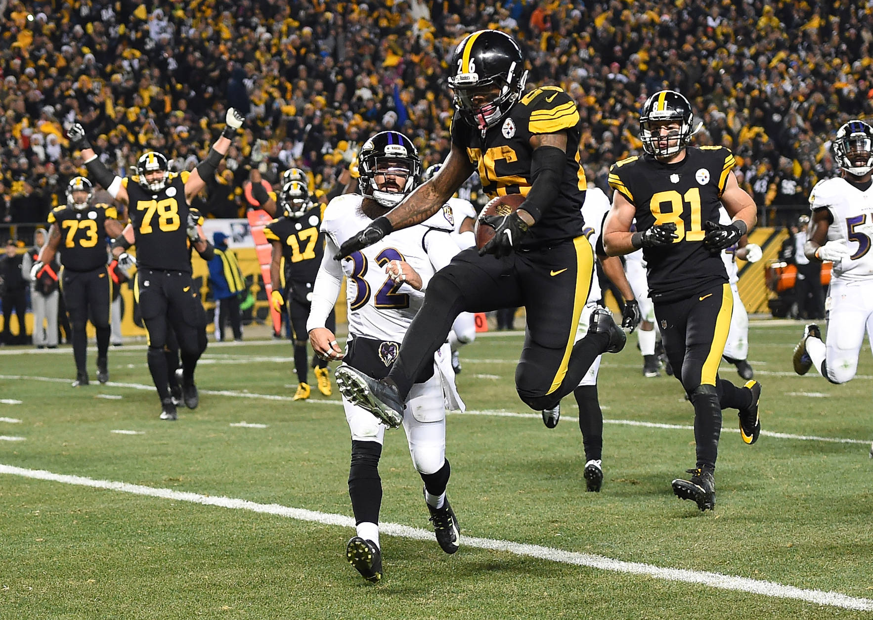 PITTSBURGH, PA - DECEMBER 25:  Le'Veon Bell #26 of the Pittsburgh Steelers leaps into the end zone in front of Eric Weddle #32 of the Baltimore Ravens for a 7 yard rushing touchdown in the fourth quarter during the game at Heinz Field on December 25, 2016 in Pittsburgh, Pennsylvania. (Photo by Joe Sargent/Getty Images)