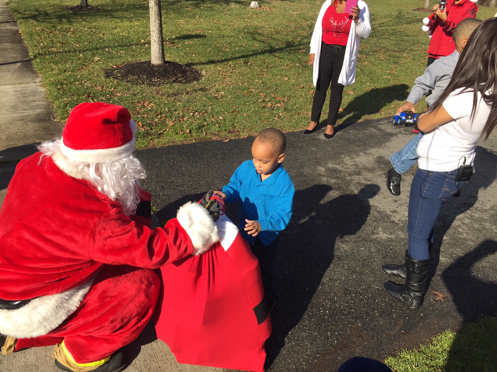 Santa hands a bag of toys to a boy in Upper Marlboro, Md. on Sunday, Dec. 25. 2016. Police say he and his brother were victims of domestic violence. The boys were reunited with their rescuer on Sunday. (WTOP/John Domen)