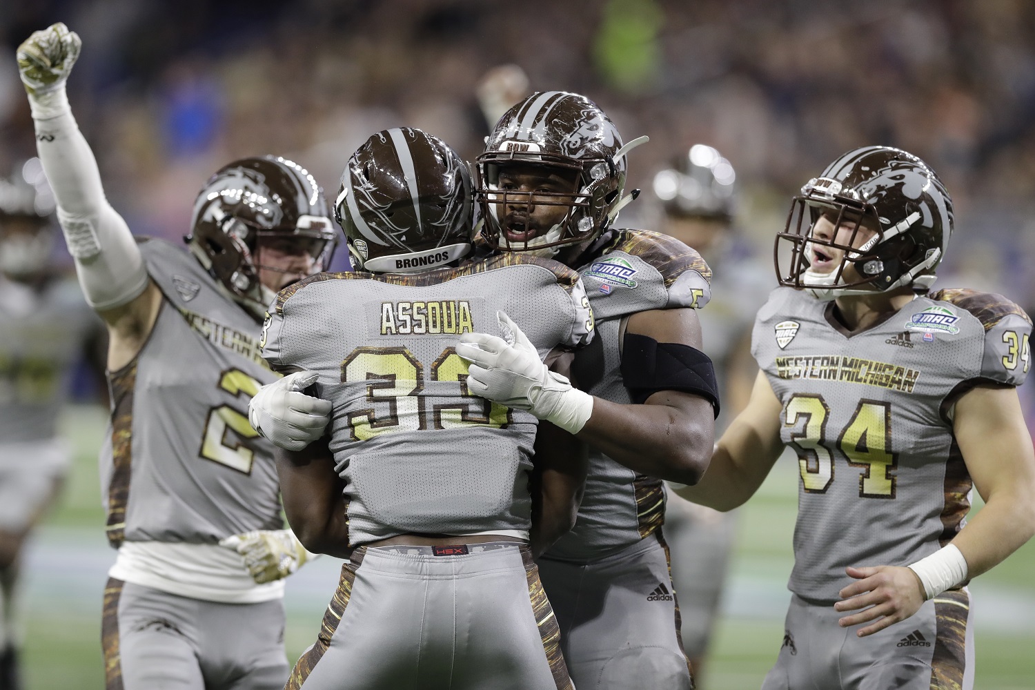 Western Michigan players celebrate a sack by defensive lineman Eric Assoua (33) during the first half of the Mid-American Conference championship NCAA college football game against Ohio, Friday, Dec. 2, 2016, in Detroit. (AP Photo/Carlos Osorio)