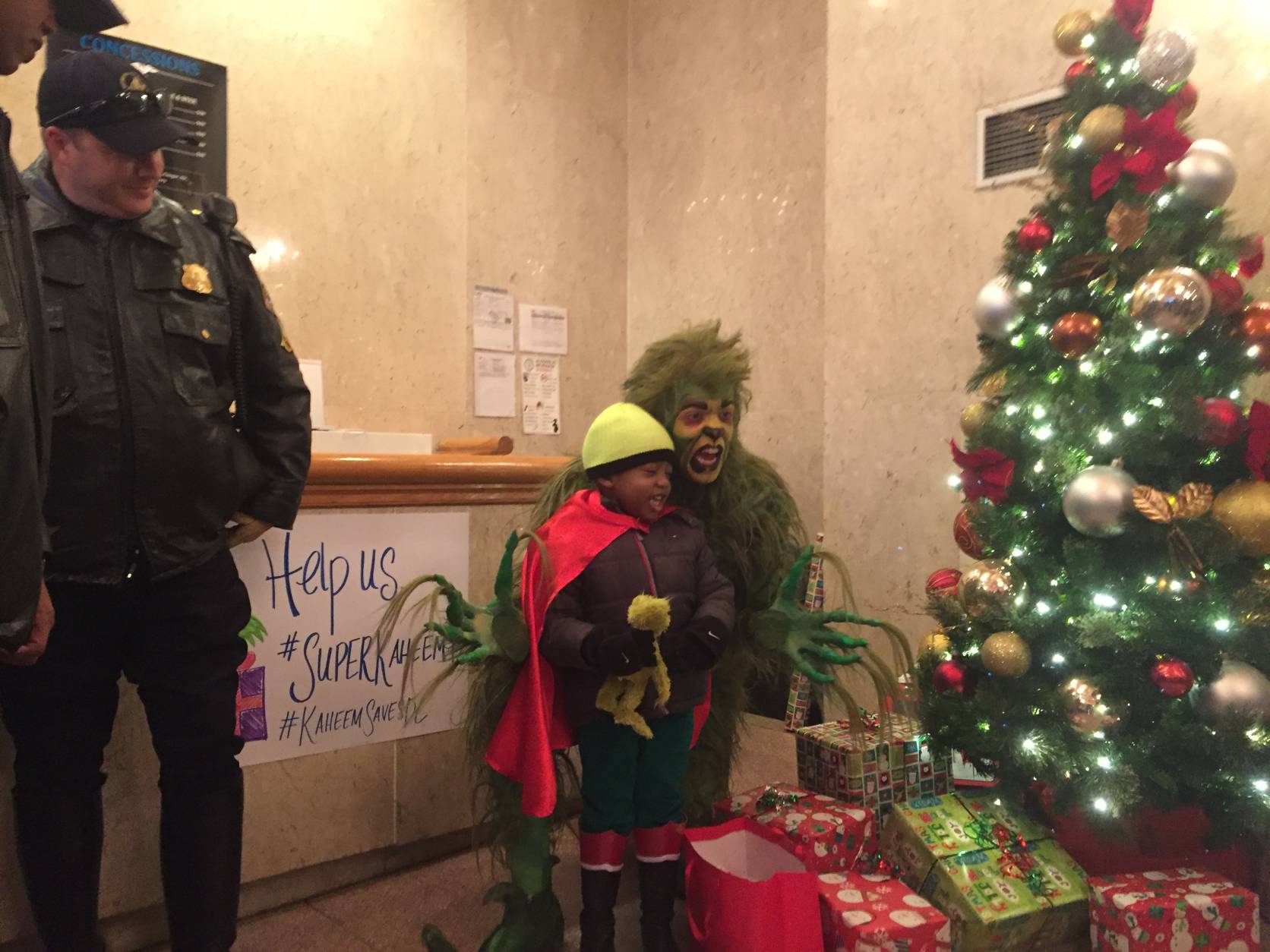 "Super Kaheem" apprehends the Grinch, who stole presents. The 5-year-old boy who has leukemia was a superhero for a day, courtesy of the Make-A-Wish Foundation. (WTOP/Mike Murillo)