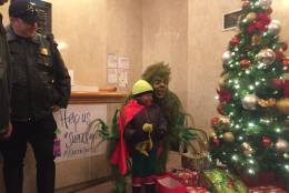 "Super Kaheem" apprehends the Grinch, who stole presents. The 5-year-old boy who has leukemia was a superhero for a day, courtesy of the Make-A-Wish Foundation. (WTOP/Mike Murillo)