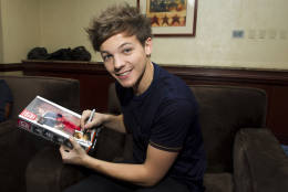 Member of worldwide musical sensation One Direction Louis Tomlinson signs his Hasbro doll at a press event on Monday, Nov. 26, 2012 in New York. (Photo by Charles Sykes/Invision for Hasbro/AP Images)