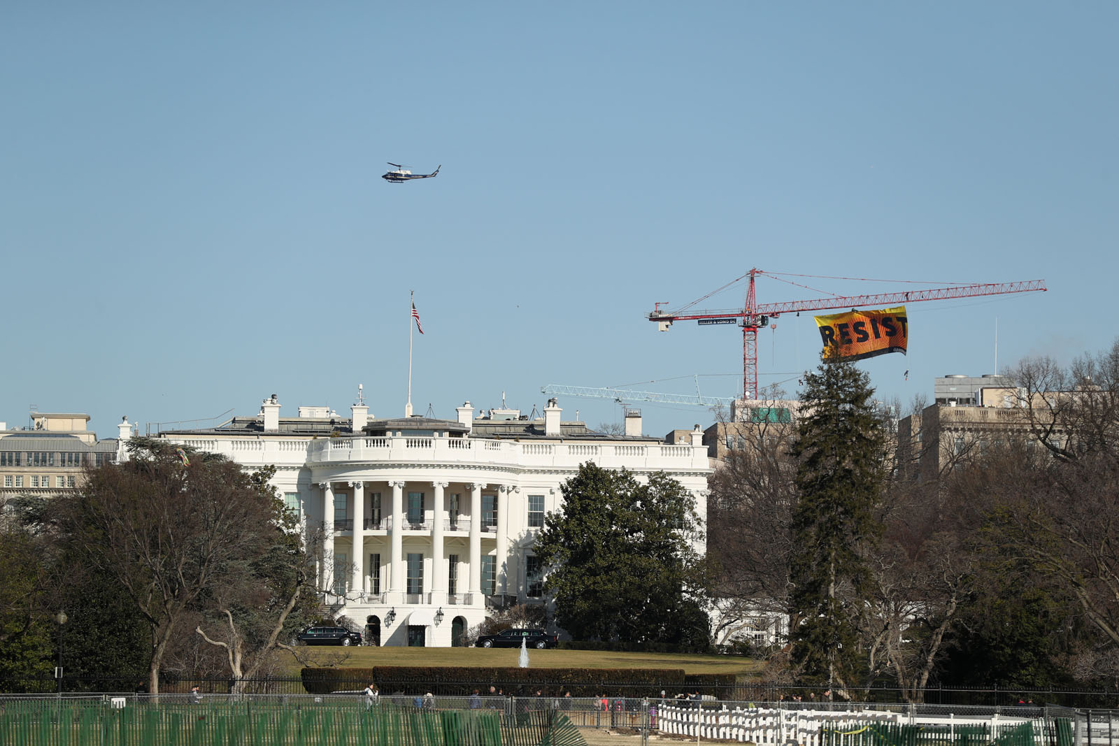 Greenpeace protesters unfurl a banner that reads "Resist" at the construction site of the former Washington Post building, near the White House in Washington, Wednesday, Jan. 25, 2017, after police say protesters climbed a crane at the site refusing to allow workers to work in the area.  (AP Photo/Andrew Harnik)