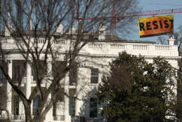 A banner unfurled by Greenpeace demonstrators that reads "Resist" is seen at the construction site of the former Washington Post building, near the White House in Washington, Wednesday, Jan. 25, 2017, after police say protesters climbed a crane at the site refusing to allow workers to work in the area.   (AP Photo/Andrew Harnik)