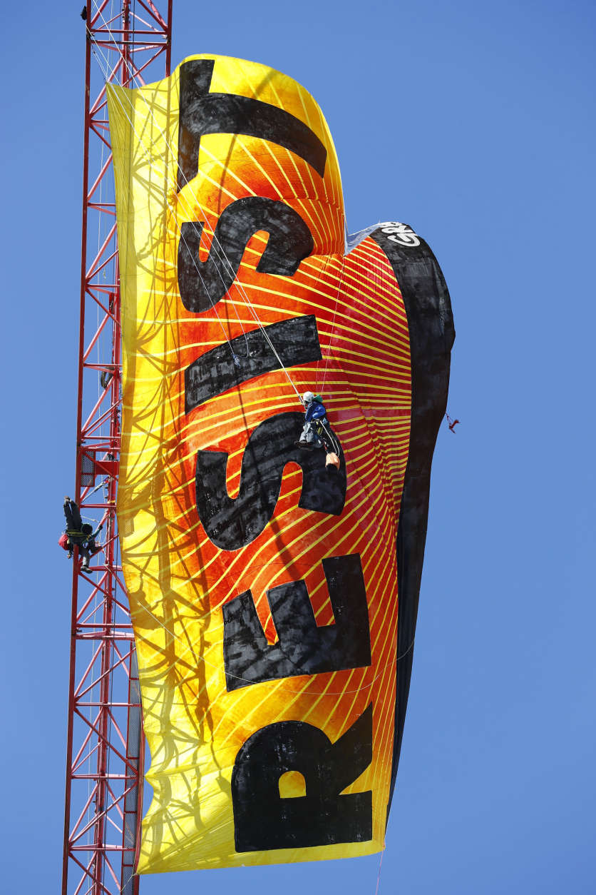 Greenpeace protesters unfurl a banner that reads "Resist" at the construction site of the former Washington Post building in Washington, Wednesday, Jan. 25, 2017, after police say protesters climbed a crane at the site refusing to allow workers to work in the area.  (AP Photo/Alex Brandon)