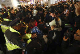 Protesters scuffle with police after refusing to vacate the sidewalk in front of the National Press Club Building ahead of the presidential inauguration, Thursday, Jan. 19, 2017, in Washington. (AP Photo/John Minchillo)