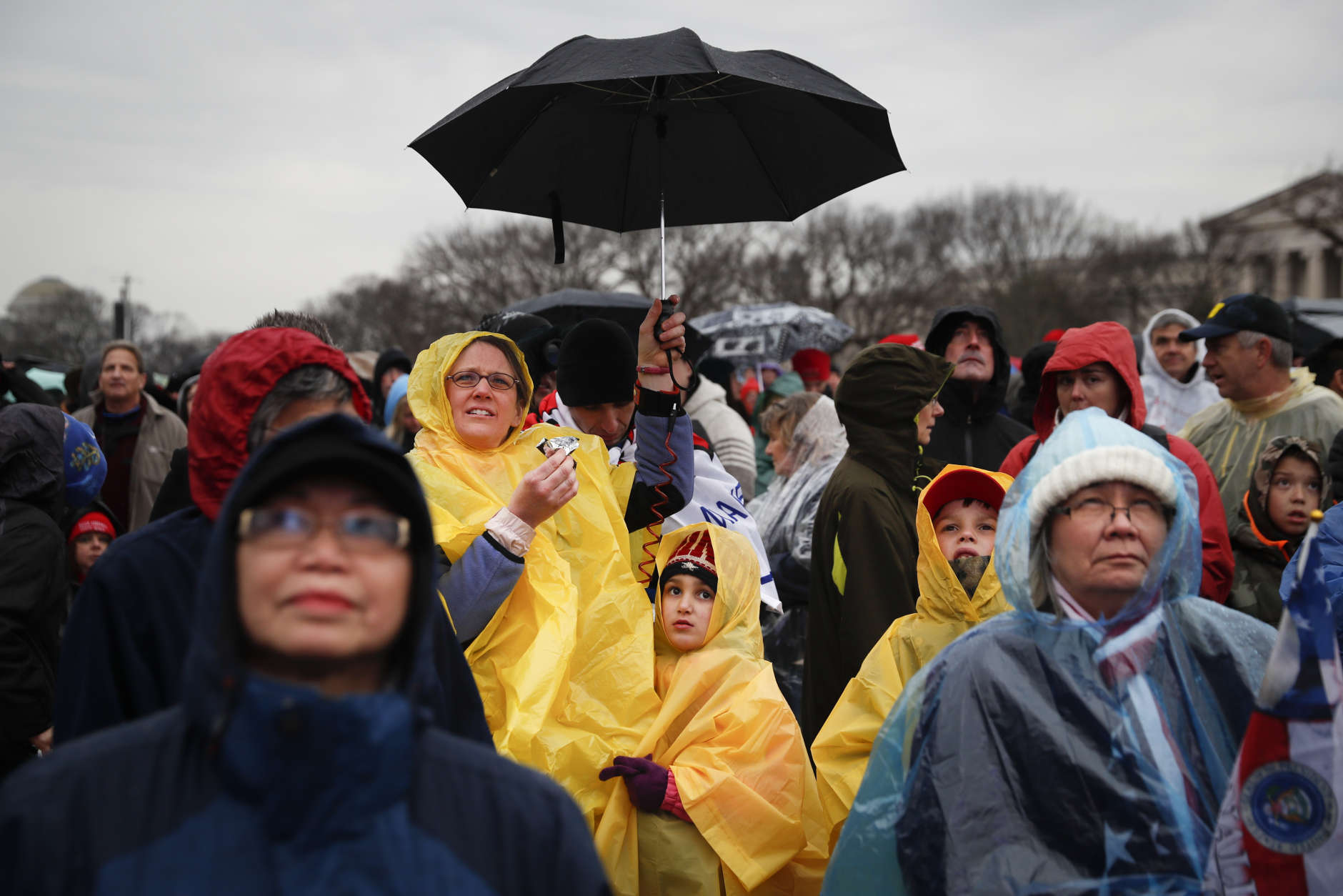 Spectators wait in the rain on the National Mall in Washington, Friday, Jan. 20, 2017, before the presidential inauguration of Donald Trump. (AP Photo/John Minchillo)