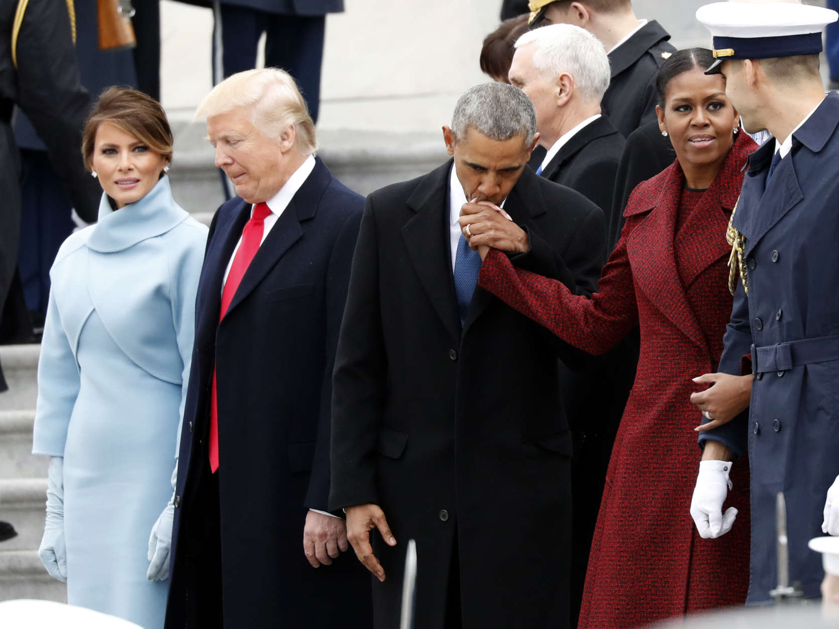 First lady Melania Trump stands with President Donald Trump as former President Barack Obama kisses the hand of his wife Michelle Obama, during a departure ceremony on the East Front of the U.S. Capitol, Friday, Jan. 20, 2017 in Washington. (AP Photo/Alex Brandon)
