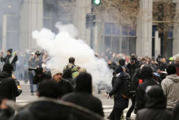 Police deploy smoke and pepper grenades during clashes with protesters in northwest Washington, Friday, Jan. 20, 2017. (AP Photo/Mark Tenally)