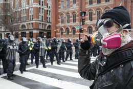 A protester faces off with a line of riot police during a demonstration after the inauguration of President Donald Trump, Friday, Jan. 20, 2017, in Washington. (AP Photo/John Minchillo)