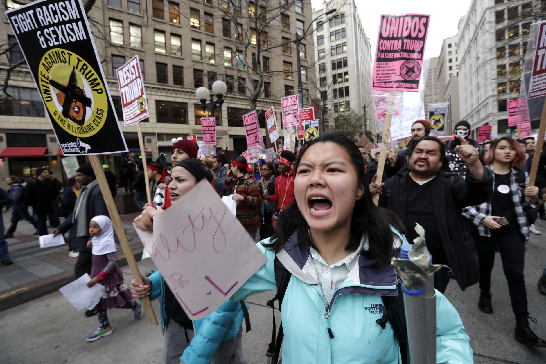 A coalition of students, immigrants, refugees and supporters fill a downtown street as they head to a rally while protesting on Inauguration Day, Friday, Jan. 20, 2017, in Seattle. (AP Photo/Elaine Thompson)