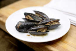 A dish of mussels roasted with pine needles is displayed during a cooking demonstration at the both annual Maine Fishermen's Forum, Thursday, March 5, 2015, in Rockport, Maine.  Maine fishermen set a state record with a catch valued at more than $585 million in 2014. (AP Photo/Robert F. Bukaty)