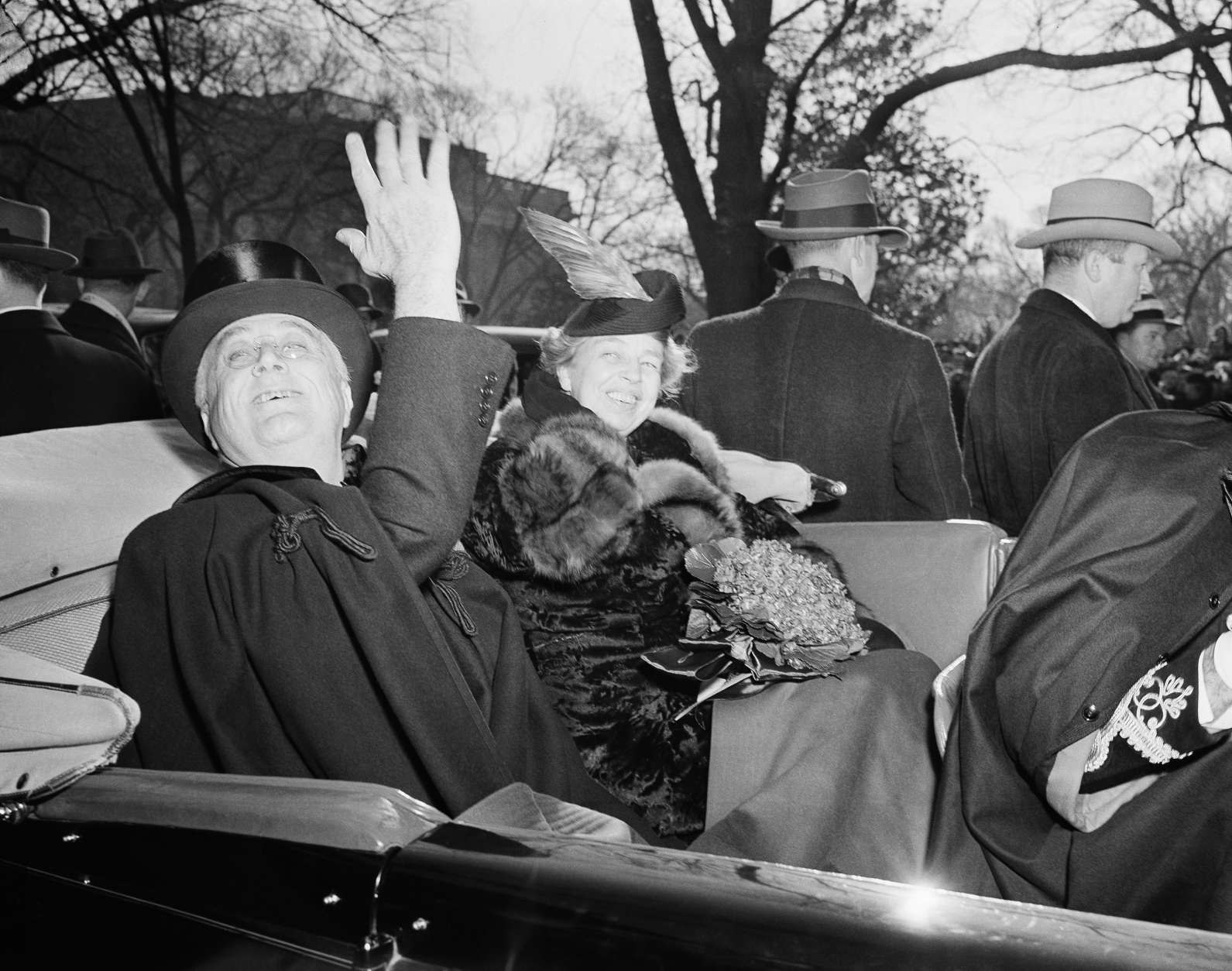 First lady Eleanor Roosevelt smiles President Franklin D. Roosevelt's side, as he waves a greeting to the crowd which cheered him as he left St. John's Church in Washington, Jan. 20, 1941, his third inaugural day. (AP Photo)
