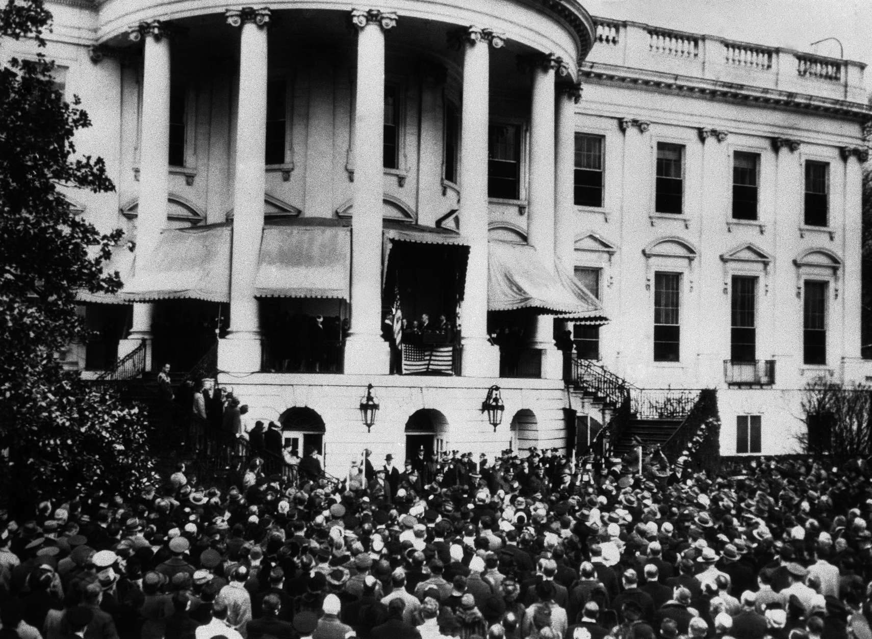 Over 7,000 people stood in the snow-covered grounds at the back of the White House to watch President Roosevelt inaugurated in Washington, on Jan. 20, 1945, for his fourth term. Wartime Austerity was the keynote of the proceedings and the whole ceremony was completed in under 15 minutes. President Roosevelt takes the oath, as diplomats, members of Congress and distinguished guests look on in foreground. On the porch are cabinet members, Supreme Court justices and their wives. Prominent in centre of porch are, left to right: Edwin Halsey, Secretary of Senate, two unidentified secret servicemen; President Roosevelt, and his son, Colonel James Roosevelt. (AP Photo)