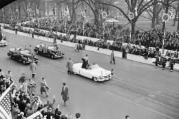 President Dwight Eisenhower, in his open car, waves to cheering spectators as he approaches the White House where he went into reviewing stand to watch the inaugural parade in Washington, Jan. 20, 1953. Crowds line Pennsylvania Avenue sidewalk. (AP Photo)