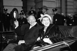 President Dwight Eisenhower and Mrs Mamie Eisenhower sit  in the open car and wave as they  leave the Capitol in Washington Jan. 21, 1957, just before swinging into Constitution Avenue on traditional inaugural parade route. (AP Photo)