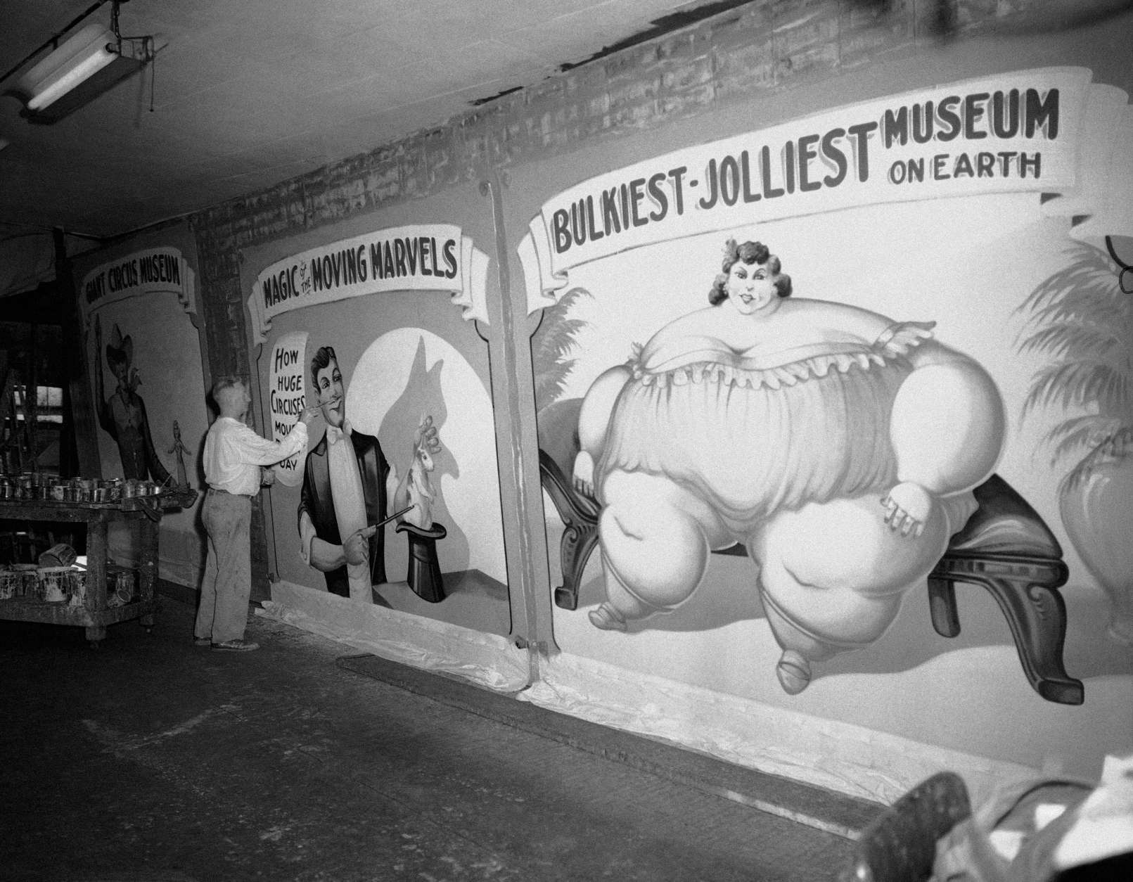 Fred Johnson, 67, a banner artist of the old school, puts the final touches to huge banners on July 14, 1959 to be used in the new circus museum being installed at Baraboo, Wis. where the John Ringling Bros., circus began. Johnson still plys his art with a Chicago tent and awning firm. He began painting circus banners in 1909. (AP Photo/Edward Kitch)