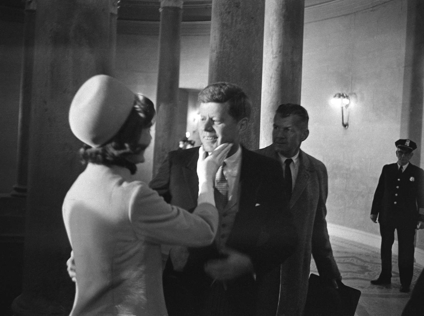 Mrs. Jacqueline Kennedy has a chuck under the chin for her husband moments after he became president, January 20, 1961. This exclusive picture by AP photographer Henry Burroughs was taken in the rotunda of the Capitol just after President John F. Kennedy left the inaugural stand.  (AP Photo/Henry Burroughs)