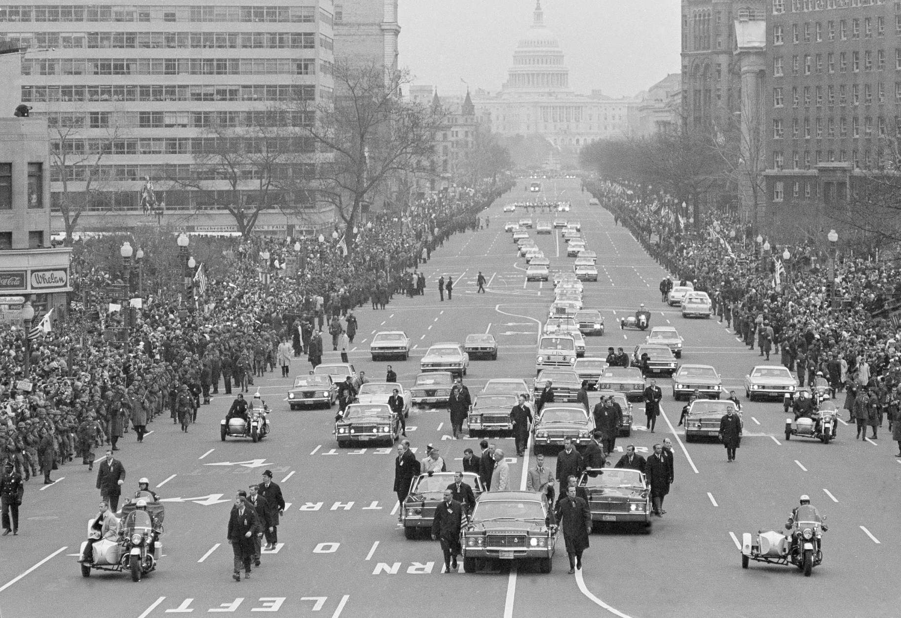The motorcade carrying President-elect Nixon and President Johnson to the inaugural ceremony drives down Pennsylvania Avenue toward the U.S. Capitol in Washington, Jan. 20, 1969.  The incoming and outgoing chief executives are in the flag-decked car flanked by the Secret Service cars. (AP Photo)
