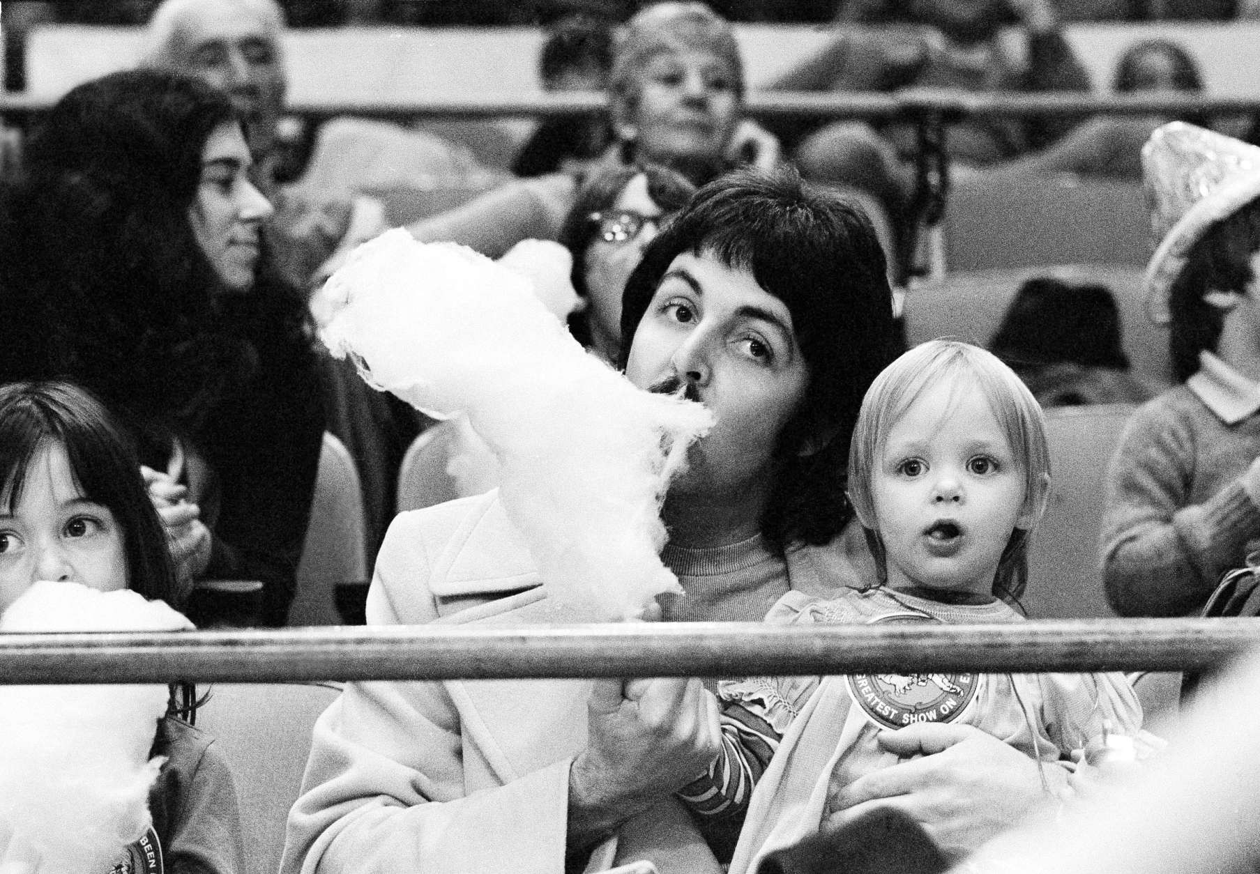 Former Beatle Paul McCartney samples his young daughter Stella's cotton candy as the two sit on the sidelines at New York's Madison Square Garden, March 30, 1974, watching the Ringling Bros. &amp; Barnum and Bailey Circus. (AP Photo/Suzanne Vlamis)