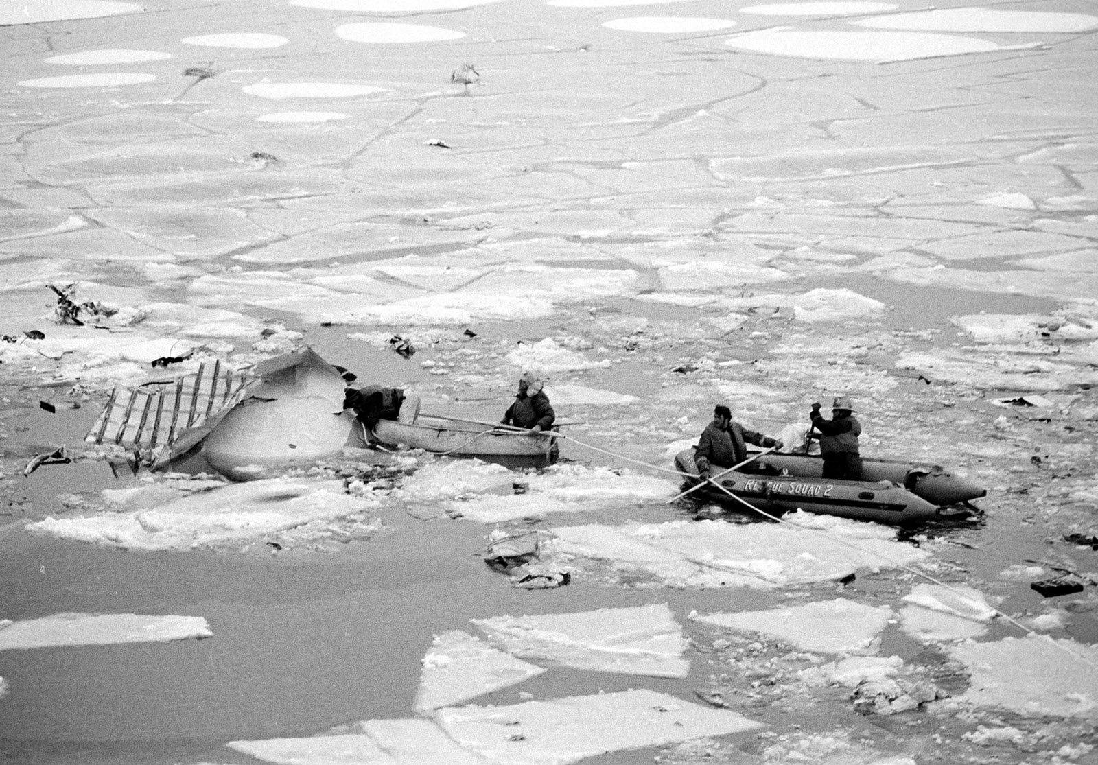 Wreckage and broken ice floats in the Potomac River in Washington, on January 13, 1982, shortly after an Air Florida jetliner hit the 14th Street bridge and crashed into the river. Rescue workers in rafts are searching for survivors. (AP Photo/Scott Stewart)