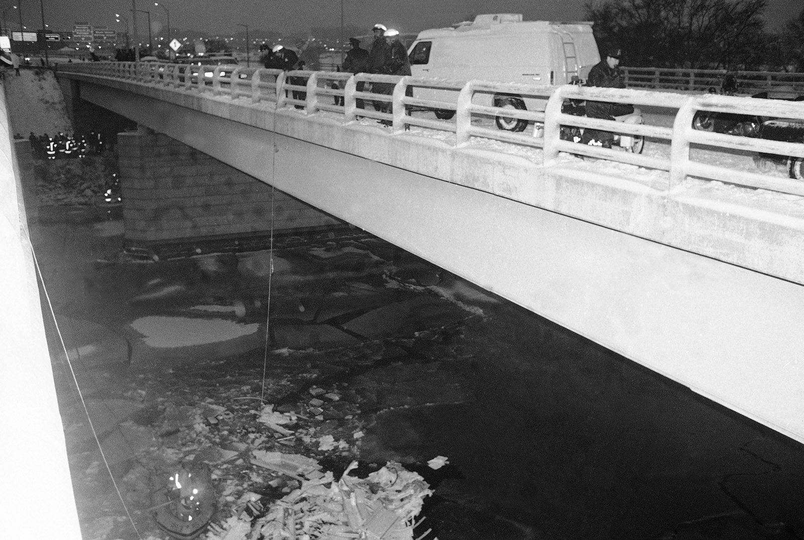 Rescue workers drop a line of the 14th Street Bridge following the crash of an Air Florida jetliner in Washington on Wednesday, Jan. 14, 1982. Hitting the bridge and several cars and trucks, the plane landed in the Potomac River. (AP Photo)