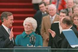 President George Bush raises his right hand as he is sworn into office as the 41st president of the United States by Chief Justice William Rehnquist outside the west front of the Capitol on Jan. 20, 1989.  First lady Barbara Bush holds the bible for her husband.  Former President Reagan is in the background.  (AP Photo/Bob Daugherty)