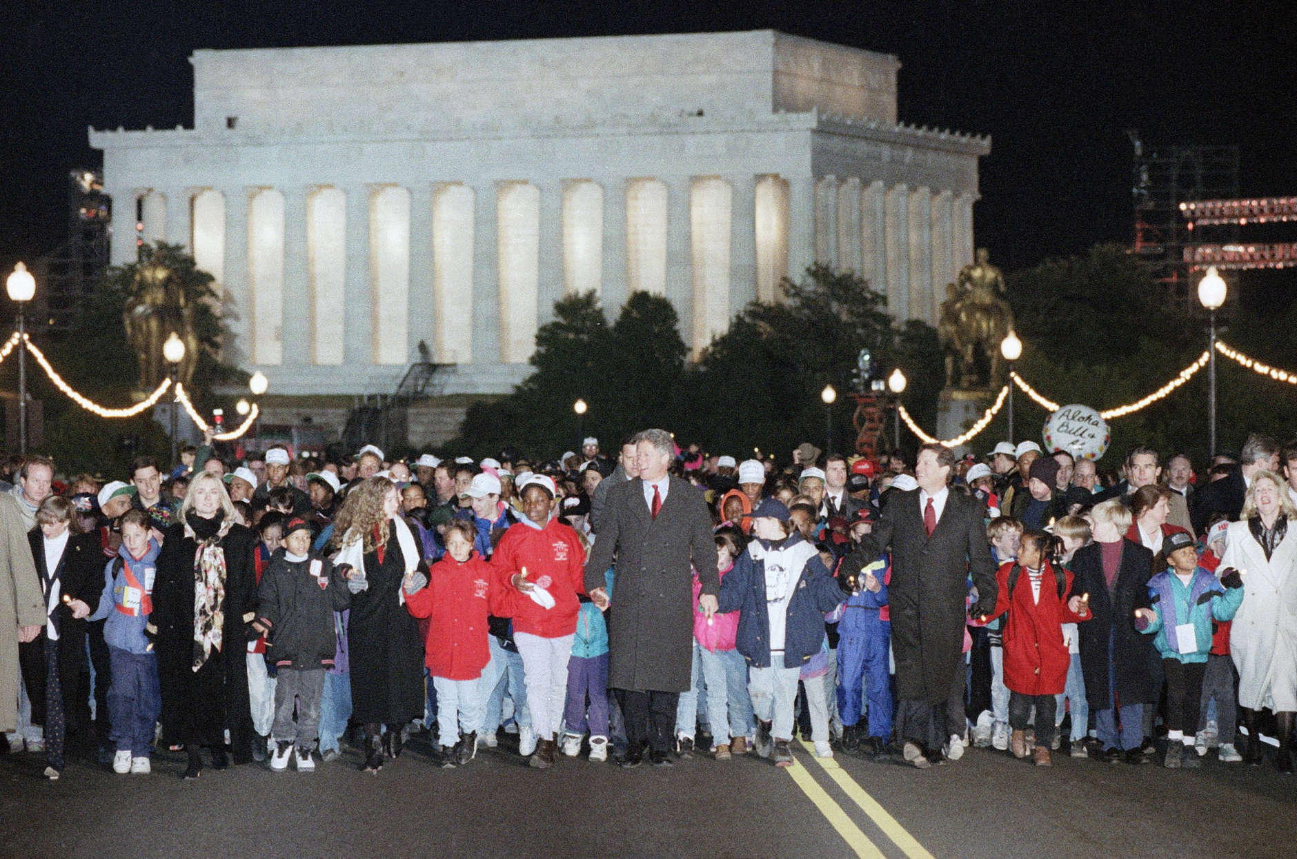 President-elect Bill Clinton, center, joins hands with others as he crosses the Memorial Bridge, built to symbolize the reunion of  North and South after the Civil War, Sunday, Jan. 17, 1993, Washington, D.C. During the inaugural festivities Clinton told those gathered we must go forward to get here or not at all and to reach out beyond the forces that divide us. (AP Photo/Greg Gibson)