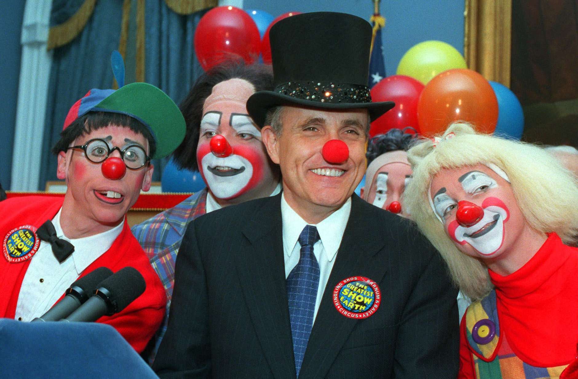 New York City Mayor Rudolph W. Giuliani, center, doffed with a red clown nose and ringmaster's top hat, is joined by Ringling Brothers Barnum and Bailey Circus clowns Chris Allison, left, and Karen DeSanto, right, at City Hall Tuesday, Feb. 23, 1999, in New York.  (AP Photo/Marty Lederhandler)