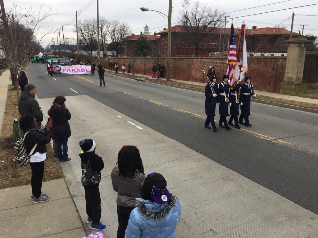 Onlookers place their hands over their hearts as the Color Guard marches pass during the 11th annual Dr. Martin Luther King, Jr. Parade in Washington, D.C. Monday, Jan. 16, 2017. (WTOP/Kristi King)