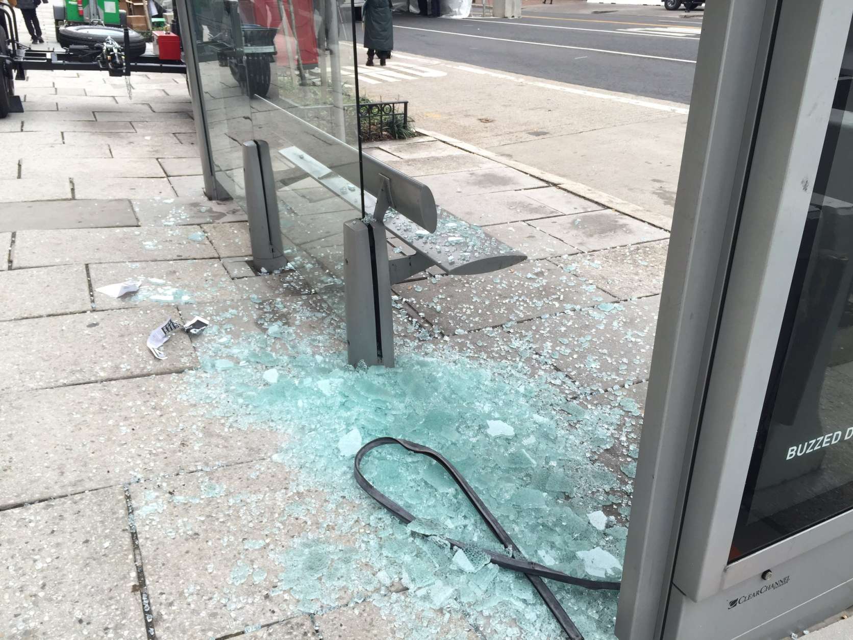 Protesters damage a bus stop on 13th Street NW. (WTOP/Dennis Foley)