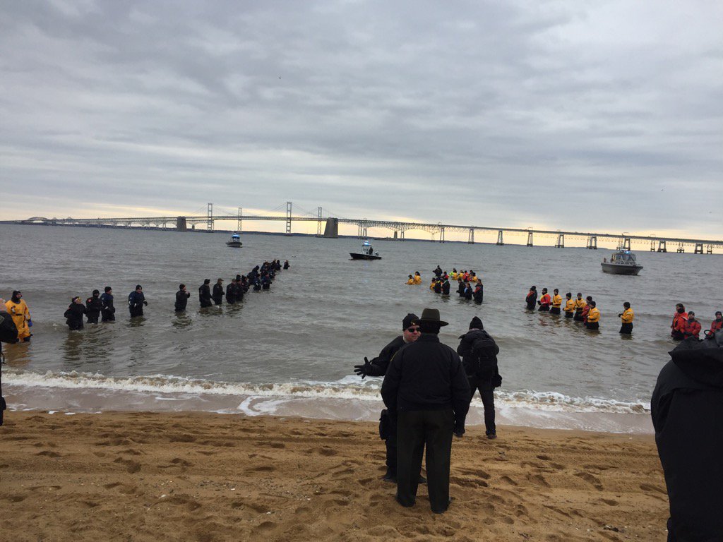 Those in the water for safety are quite appropriately dressed.  Those about to jump in are wearing decidedly less. (WTOP/John Domen)