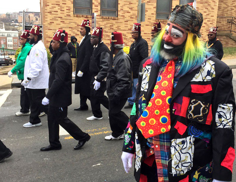 Photo of man dressed as clown marching