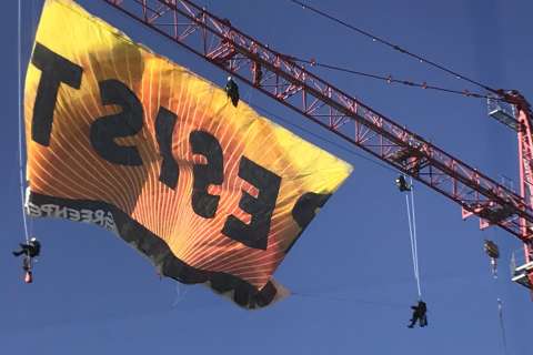 Protesters charged after unfurling banner atop DC crane