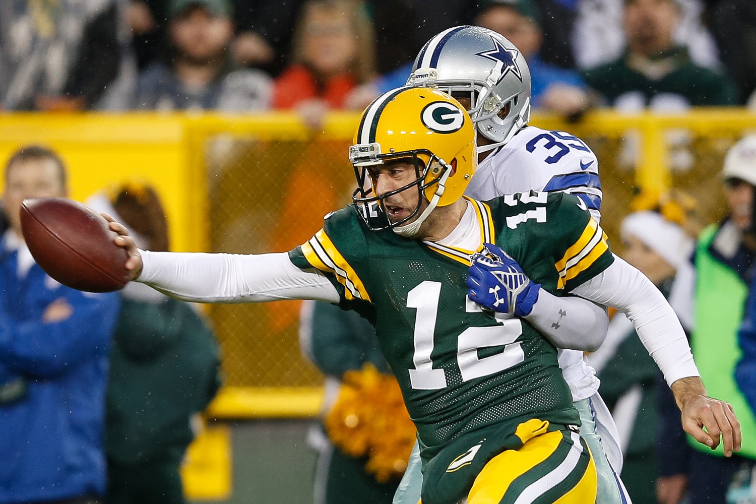 GREEN BAY, WI - DECEMBER 13:  Quarterback  Aaron Rodgers #12 of the Green Bay Packers is tackled by  Brandon Carr #39 of the Dallas Cowboys in the first half at Lambeau Field on December 13, 2015 in Green Bay, Wisconsin. The Green Bay Packers defeated the Dallas Cowboys 28 to 7.  (Photo by Joe Robbins/Getty Images)
