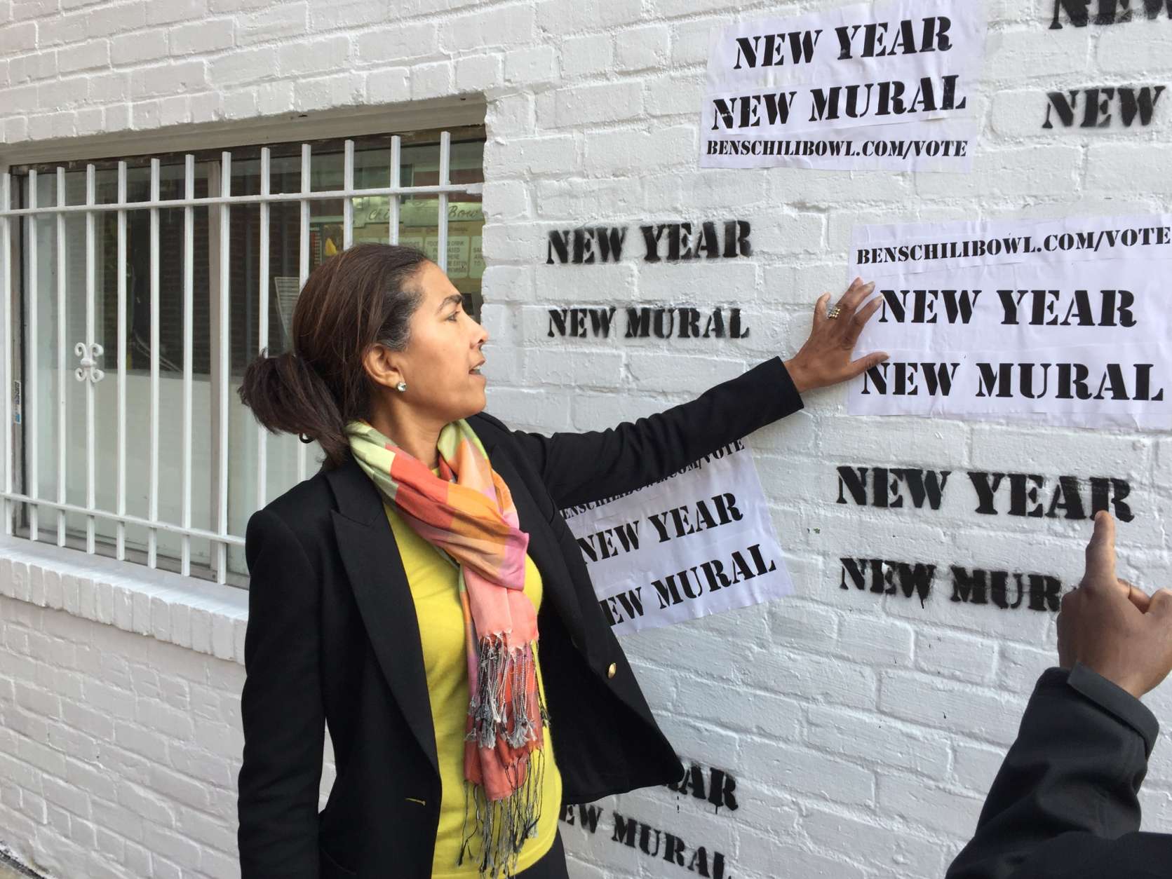 A passerby suggested some kind of "anti-Trump" message be put on the wall, but Sophia Ali, a member of the family that opened the restaurant, said that's not what the effort is about. "This is not about political action," Ali said.  (WTOP/Kristi King)