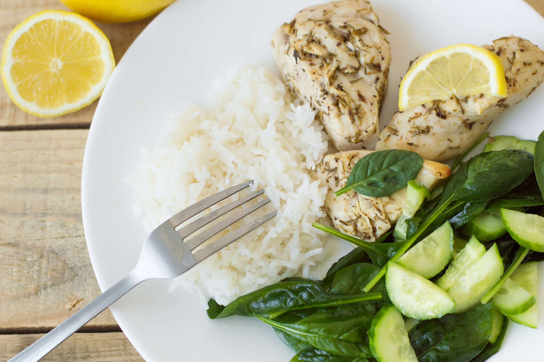 Baked chicken breasts with lemon, white rice and green spinach and cucumber salad