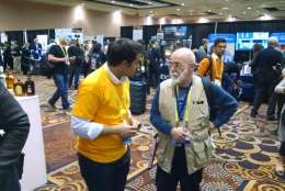 A Yummi Robotics representative visits with an attendee during "CES Unveiled." (WTOP/Steve Winter)