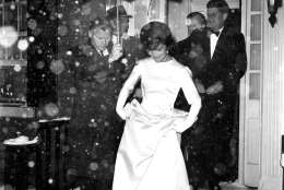 Jacqueline Kennedy lifts the skirt of her inaugural ball gown as she and her husband, President-elect John F. Kennedy, leave their Georgetown home in the snowfall en route to the inaugural concert in Washington, D.C., Jan. 19, 1961. (AP Photo)