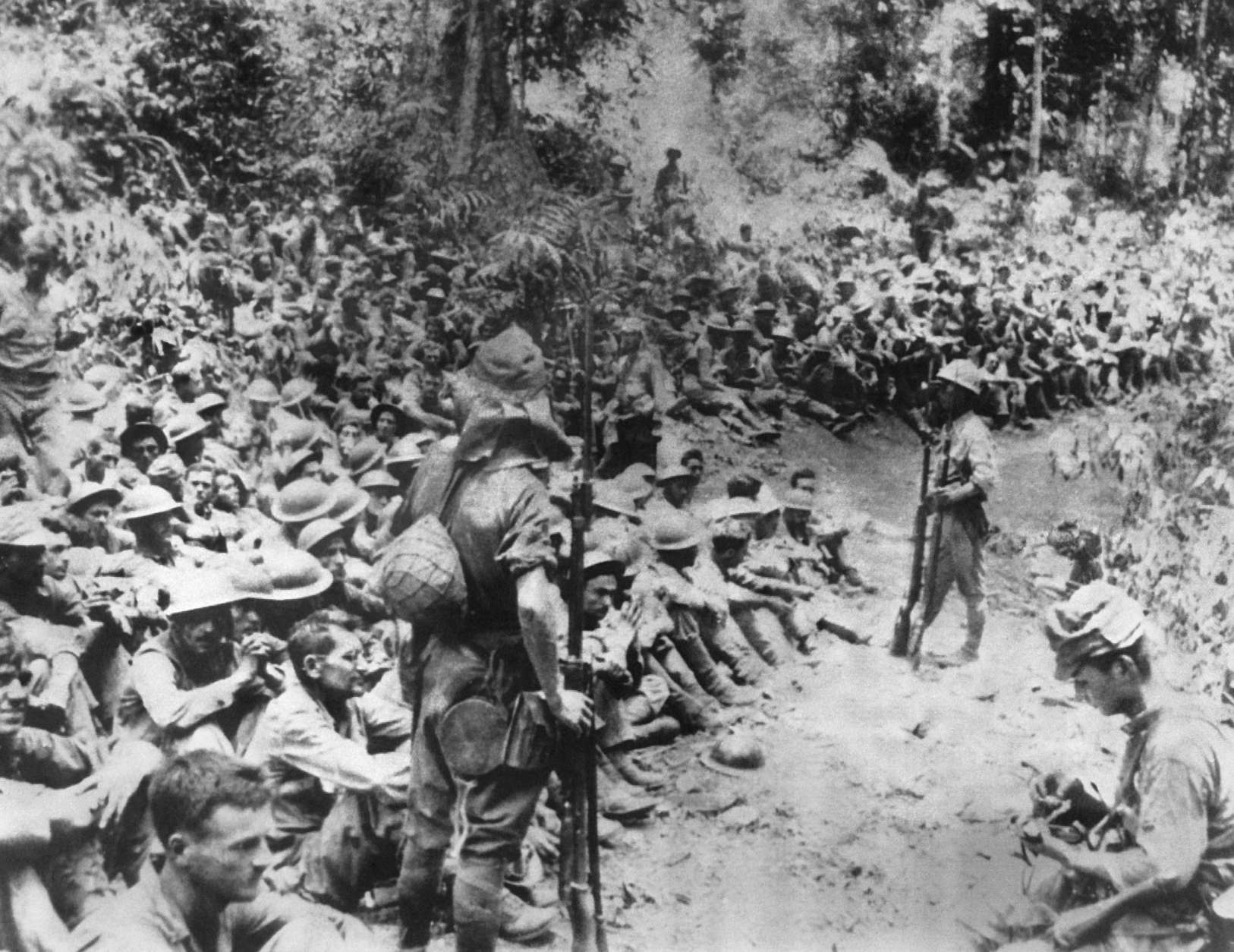 Japanese soldiers stand guard over American war prisoners just before the start of the "March of Death" for the soldiers of Bataan and Corregidor in 1942.  This photograph was stolen from the Japanese by the Philippines during Japan's three-year occupation in World War II.  (AP Photo/U.S. Marine Corps)