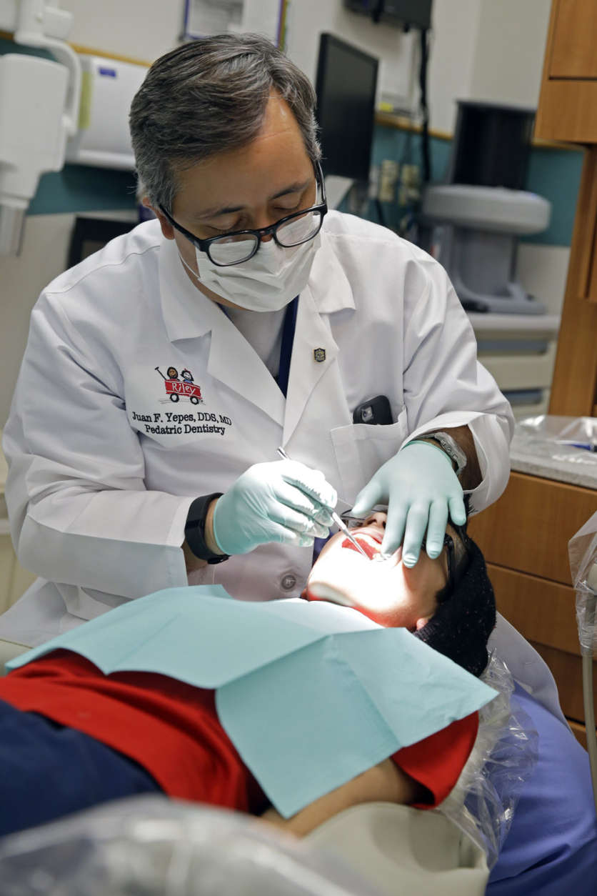 In this Friday, Jan. 22, 2016 photo, Dr. Juan Fernando Yepes, a dentist at the Riley Hospital for Children Department of Pediatric Dentistry, checks the teeth of Justin Perez, 11, during an office visit in Indianapolis. Dentistry sits atop U.S. News and World Report's annual Best Jobs list. Health care fields dominate the list. (AP Photo/Michael Conroy)