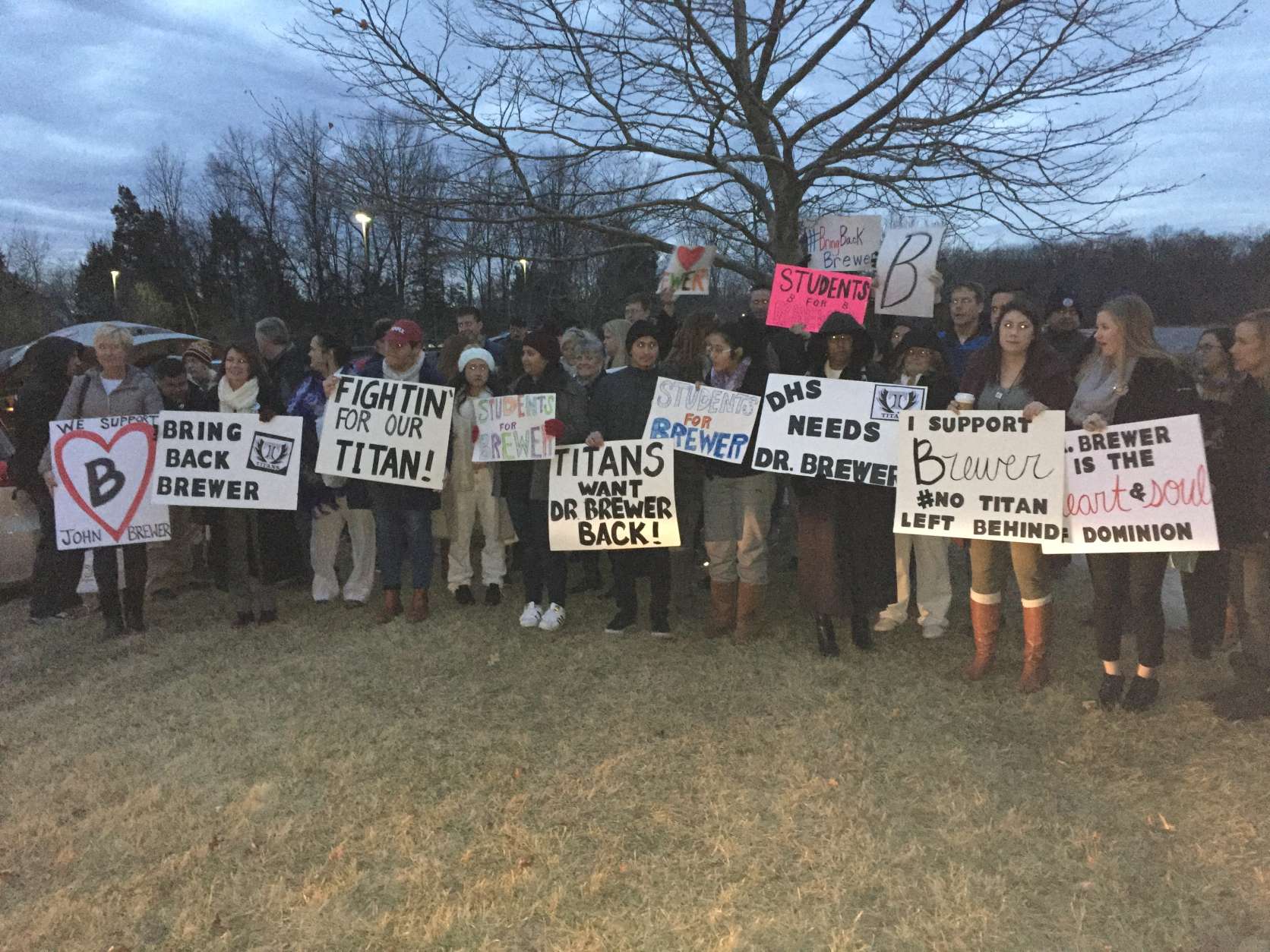 Before Tuesday's Loudoun County School Board meeting, supporters of Dominion High Principal Dr. John Brewer gathered with signs right outside. (WTOP/Michelle Basch)