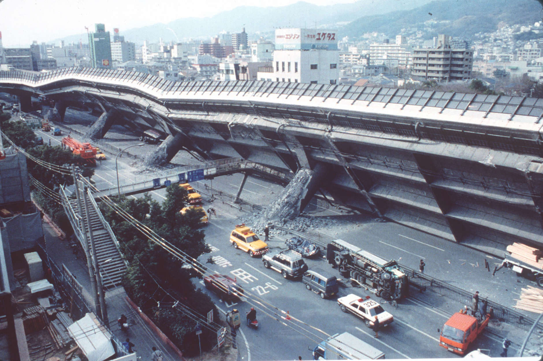 COLLAPSED HIGHWAY: Police and firemen survey the extensive damage to the collapsed Kobe-Osaka highway in Eastern Kobe, Wednesday, January 18, 1995. The elevated highway collapsed when a major 7.2 magnitude earthquake hit this Western Japan port city Tuesday morning. More than 4,000 were killed in the disaster. (AP-Photo/stf/Atsushi Tsukada/-01/18/1995-)