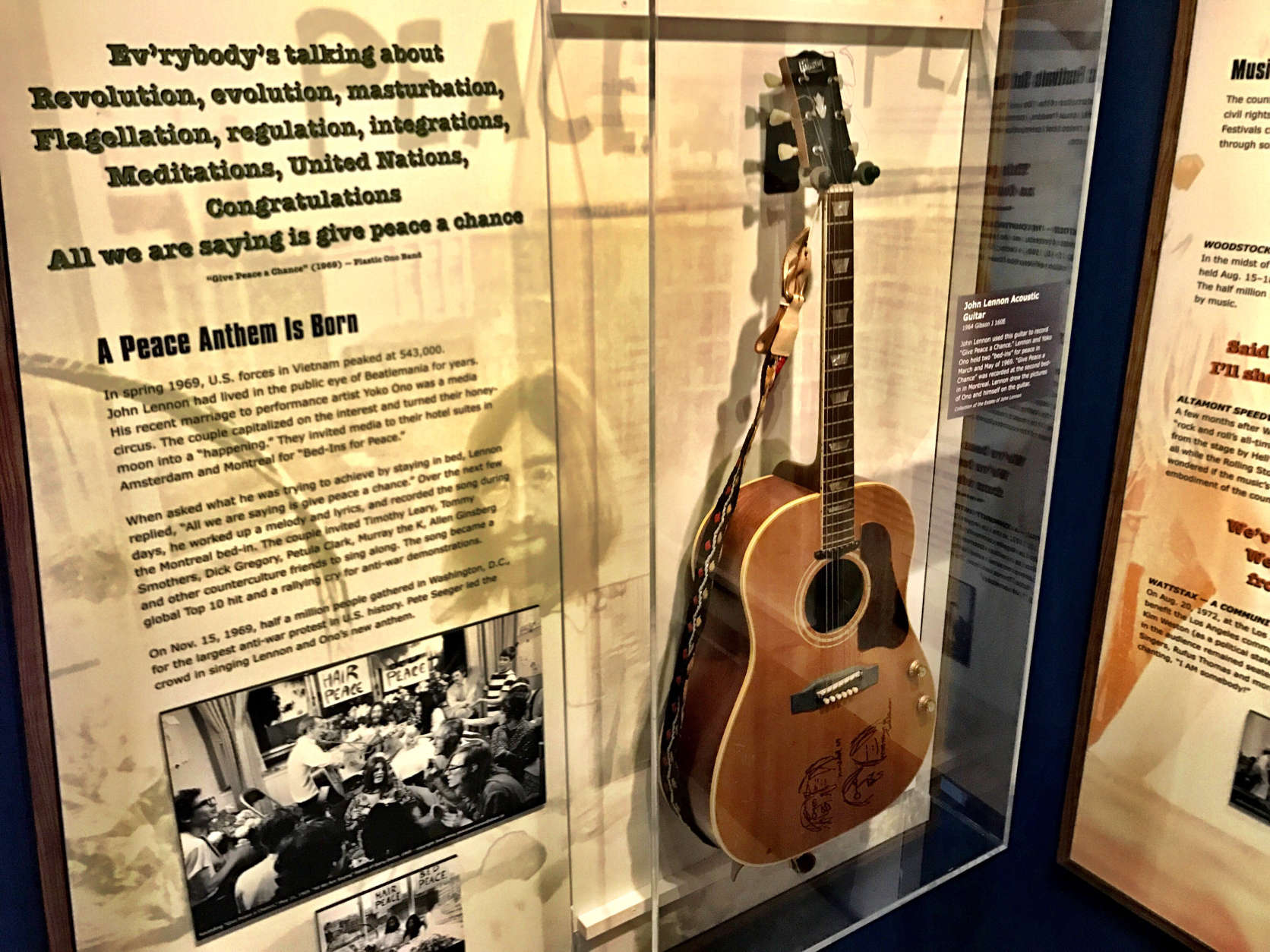 John Lennon's acoustic guitar from his 1969 Montreal and Amsterdam "Bed-Ins for Peace," on display at the Newseum. (WTOP/Neal Augenstein)