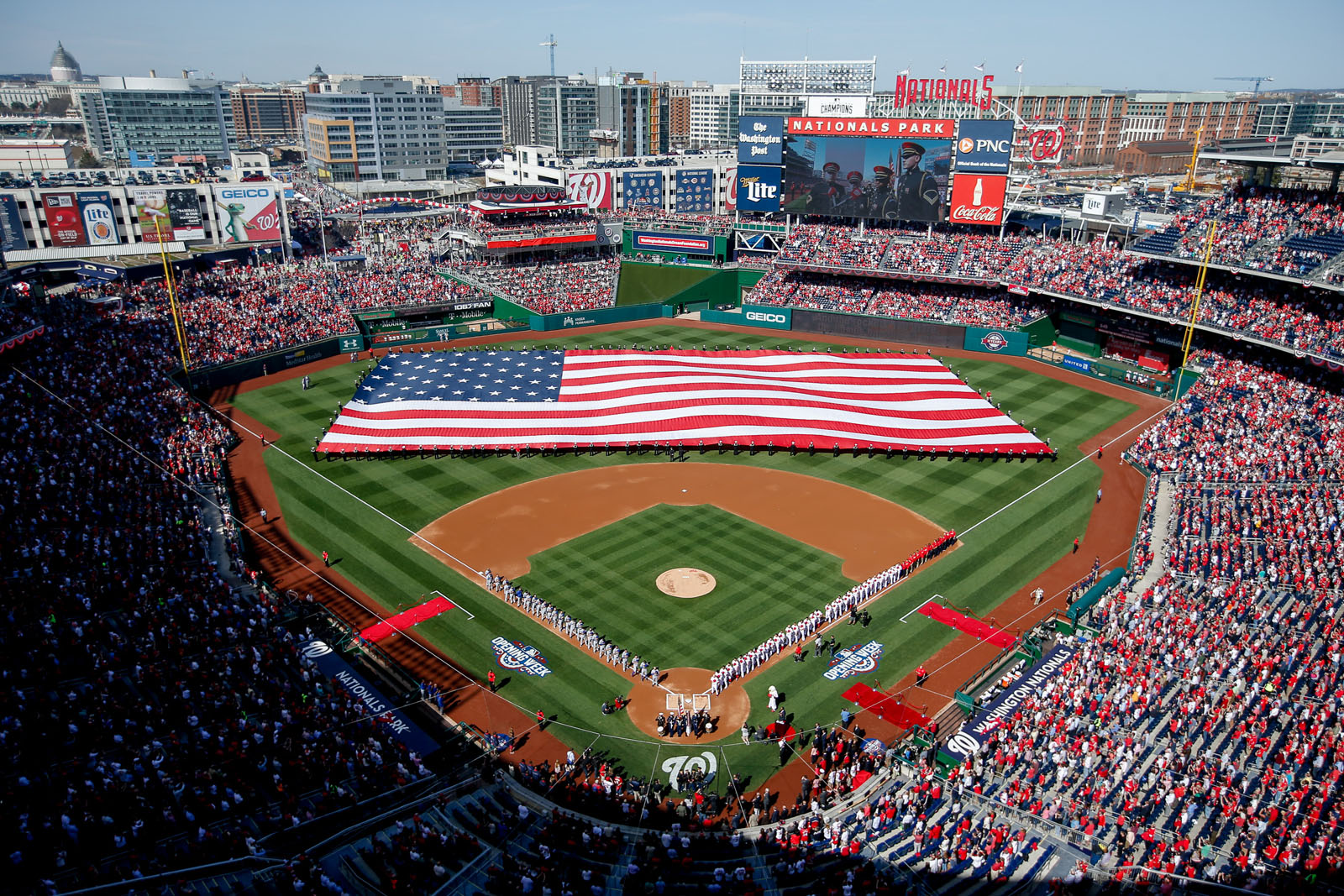 A large American flag is unfurled on the field before a baseball game between the Washington Nationals and the New York Mets on opening day at at Nationals Park, Monday, April 6, 2015, in Washington. (AP Photo/Andrew Harnik)