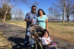 Grandparents Julio and Yolanda Gonzalez, of Beacon Hill, enjoy a stroll with 2-year-old Isabella. (WTOP/Kristi King)