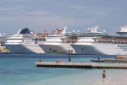 Tourists stand along the beach as cruisers are seen anchored on the shores of Nassau in Bahamas, Saturday, Sept. 6, 2008. Hurricane Ike is due to arrive in the Bahamas late Sunday. (AP Photo/Alexandre Meneghini)