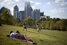 A couple enjoy a sunny afternoon against the backdrop of the Midtown skyline from Piedmont Park in Atlanta, Sunday, March 25, 2012. (AP Photo/David Goldman)